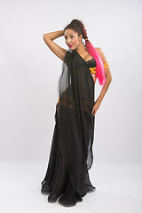 Image showing Young girl mulatto dancing in a long black dress candid