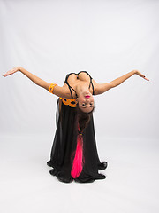 Image showing Young girl mulatto dancing in a long black dress candid