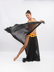 Image showing Young girl mulatto dancing in a long black dress candid