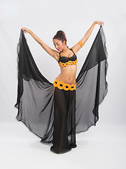 Image showing Young girl mulatto dancing in a long black dress candid