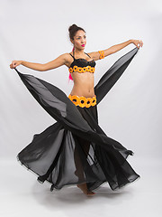 Image showing Young girl mulatto dancing in a long black dress candid