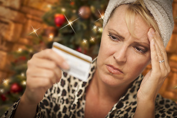 Image showing Upset Woman Holding Credit Card In Front of Christmas Tree