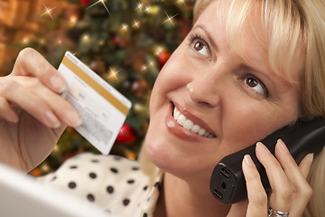 Image showing Phone Holding Woman Credit Card In Front of Christmas Tree