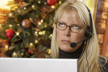 Image showing Upset Woman with Headset In Front of Christmas Tree and Computer