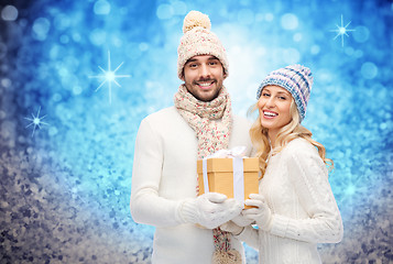 Image showing smiling couple in winter clothes with gift box