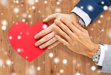 Image showing close up of male gay couple hands with red heart