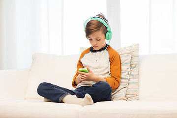 Image showing boy with smartphone and headphones at home