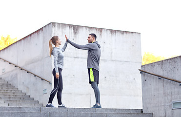 Image showing happy couple giving high five outdoors