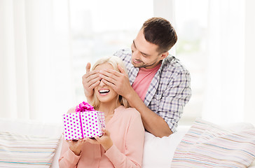 Image showing happy man giving woman gift box at home