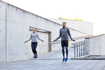 Image showing man and woman exercising with jump-rope outdoors