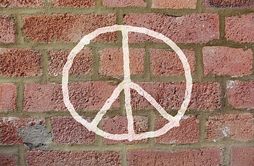 Image showing peace sign drawing on red brick wall