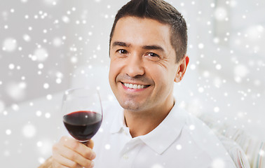 Image showing happy man drinking red wine from glass at home