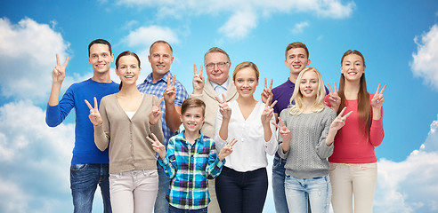 Image showing group of smiling people showing peace hand sign