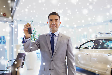 Image showing happy man showing key at auto show or car salon