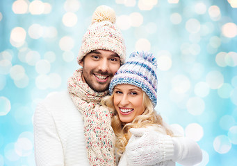 Image showing happy couple in winter clothes hugging over lights