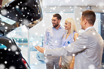 Image showing happy couple with car dealer in auto show or salon