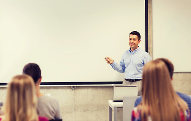 Image showing group of students and smiling teacher in classroom