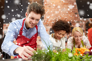 Image showing happy friends cooking and decorating dishes