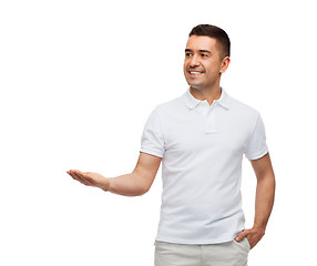 Image showing smiling man showing something on empty palm