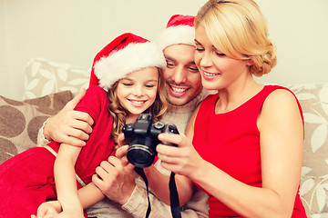 Image showing family in santa helper hats looking at pictires