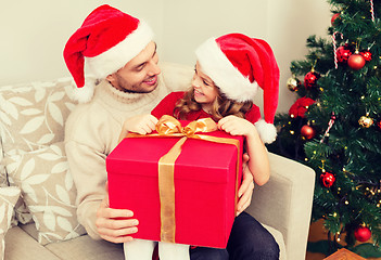 Image showing smiling father and daughter opening gift box