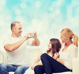 Image showing happy family with camera at home