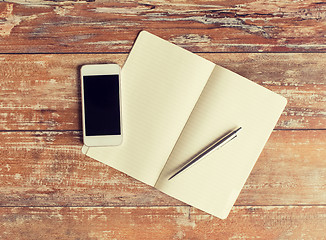 Image showing close up of notebook, pen and smartphone