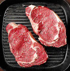 Image showing raw beef steak on cooking pan