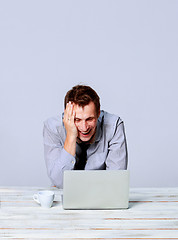 Image showing Happy man working on laptop in the office