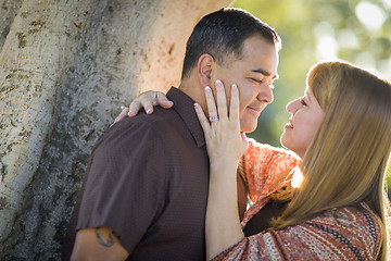 Image showing Mixed Race Couple Leaning Against Tree In a Romantic Moment