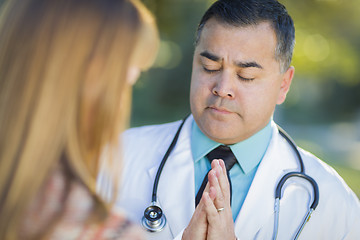 Image showing Hispanic Male Doctor Praying With A Patient