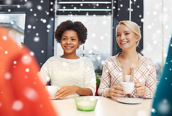 Image showing happy young women drinking tea or coffee at cafe