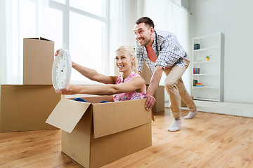 Image showing couple with cardboard boxes having fun at new home