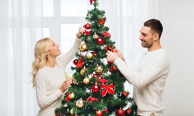 Image showing happy couple decorating christmas tree at home