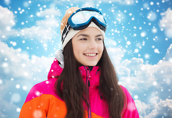 Image showing happy young woman in ski goggles over blue sky