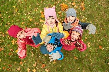 Image showing happy children waving hands in autumn park