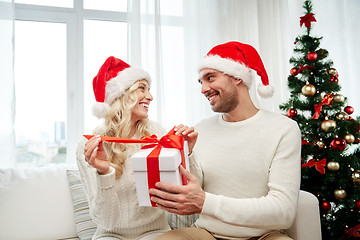 Image showing happy couple at home with christmas gift box