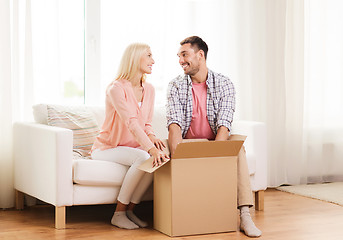 Image showing happy couple with cardboard box or parcel at home