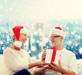 Image showing happy senior couple with gift box at home