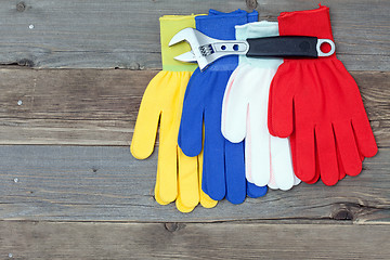 Image showing varicolored workers gloves and wrench