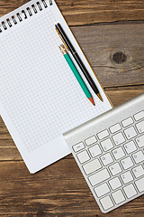 Image showing notebook on a spring, vintage pencil, pen and computer keyboard