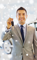 Image showing happy man showing key at auto show or car salon