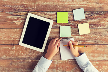 Image showing close up of hands with tablet pc and notebook