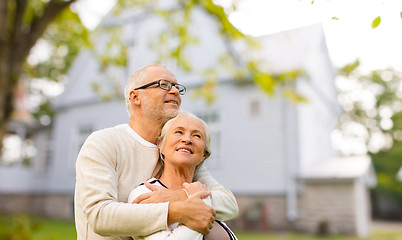 Image showing senior couple hugging over living house background