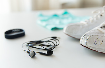 Image showing close up of earphones, bracelet and sportswear