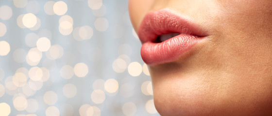 Image showing close up of young woman lips over holidays lights