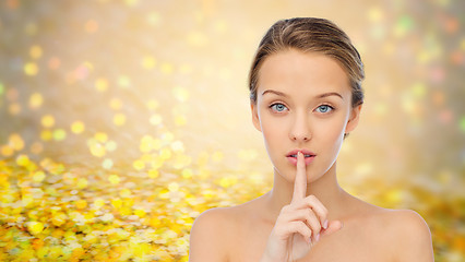 Image showing beautiful young woman holding finger on lips