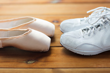 Image showing close up of sneakers and pointe shoes on wood