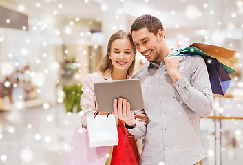 Image showing couple with tablet pc and shopping bags in mall