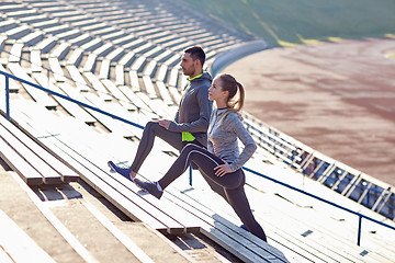 Image showing couple stretching leg on stands of stadium